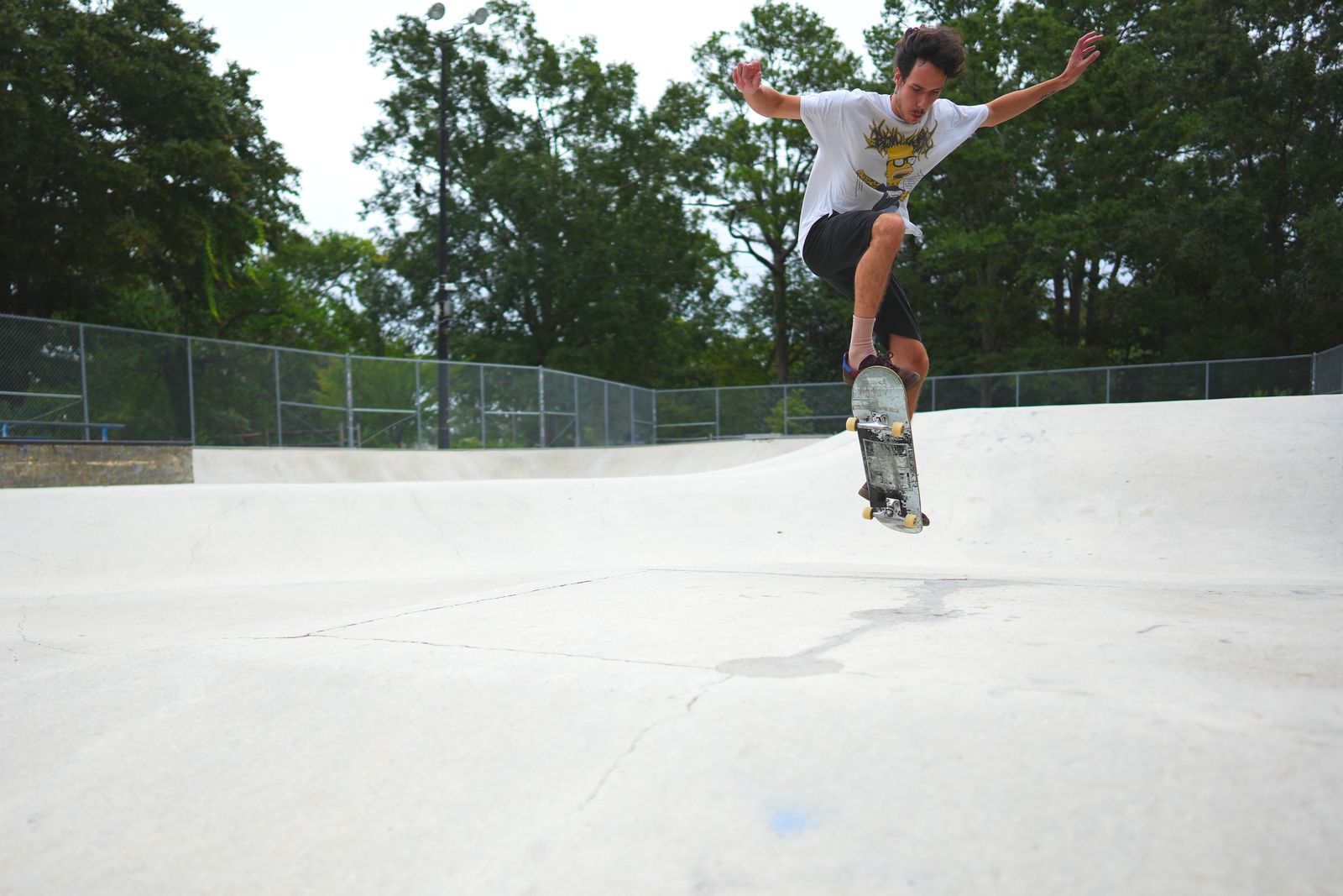 Jaden mid-ollie over the gap, board tilted beneath him, arms out