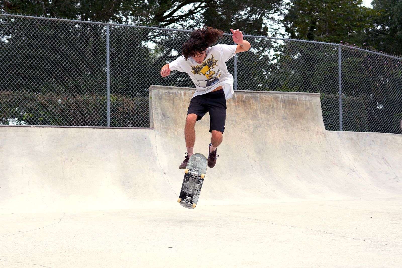 Jaden mid pop shuvit on flatground, board spinning beneath him
