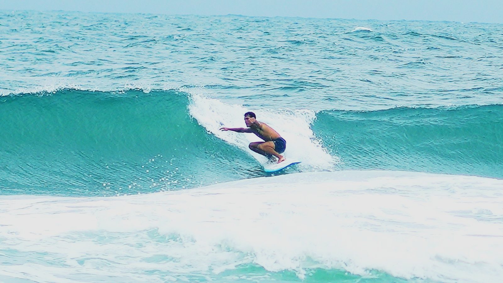 Jack crouched low in the pocket of a glassy green wave