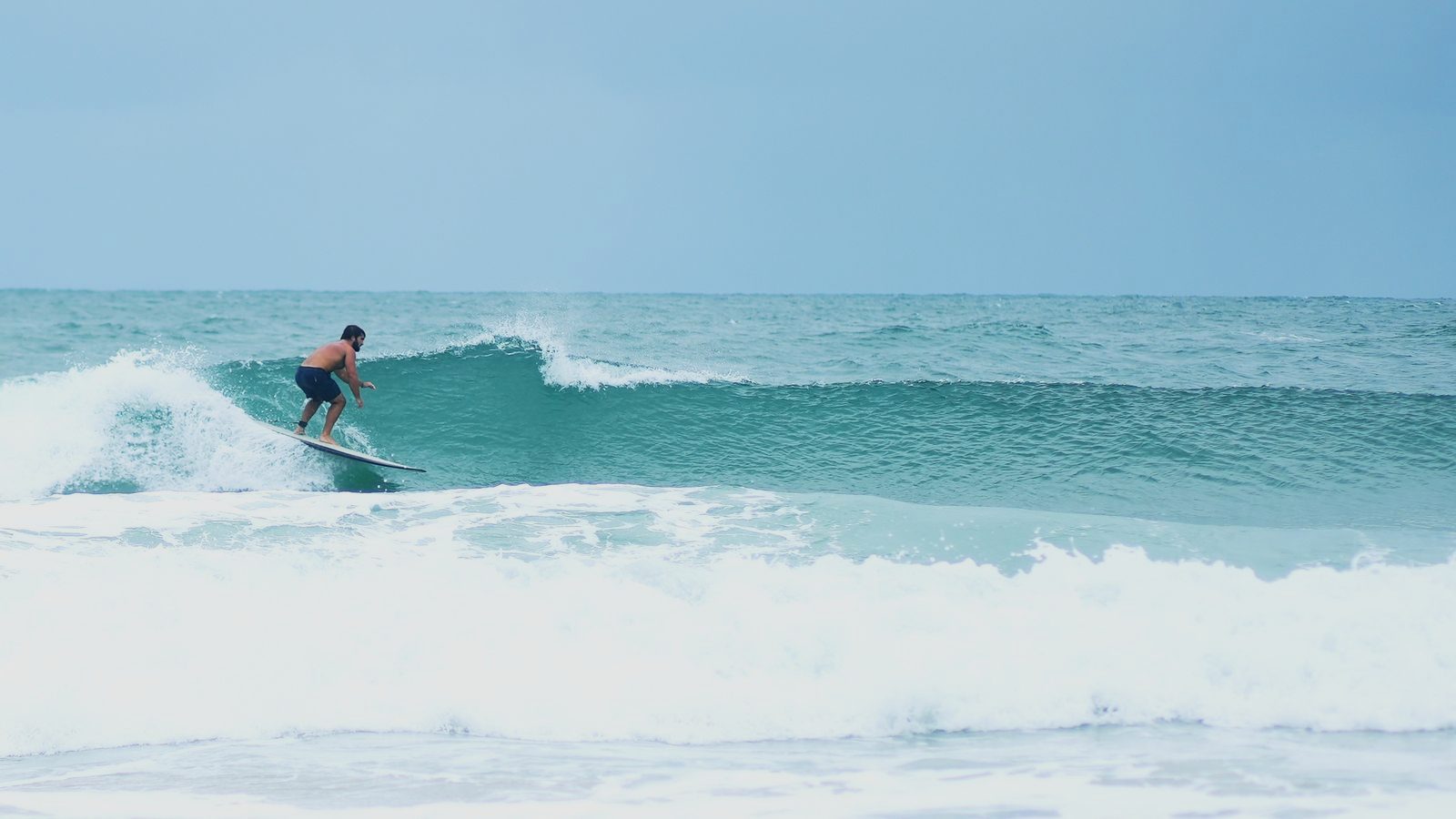 Turner riding down the line as the wave folds behind him