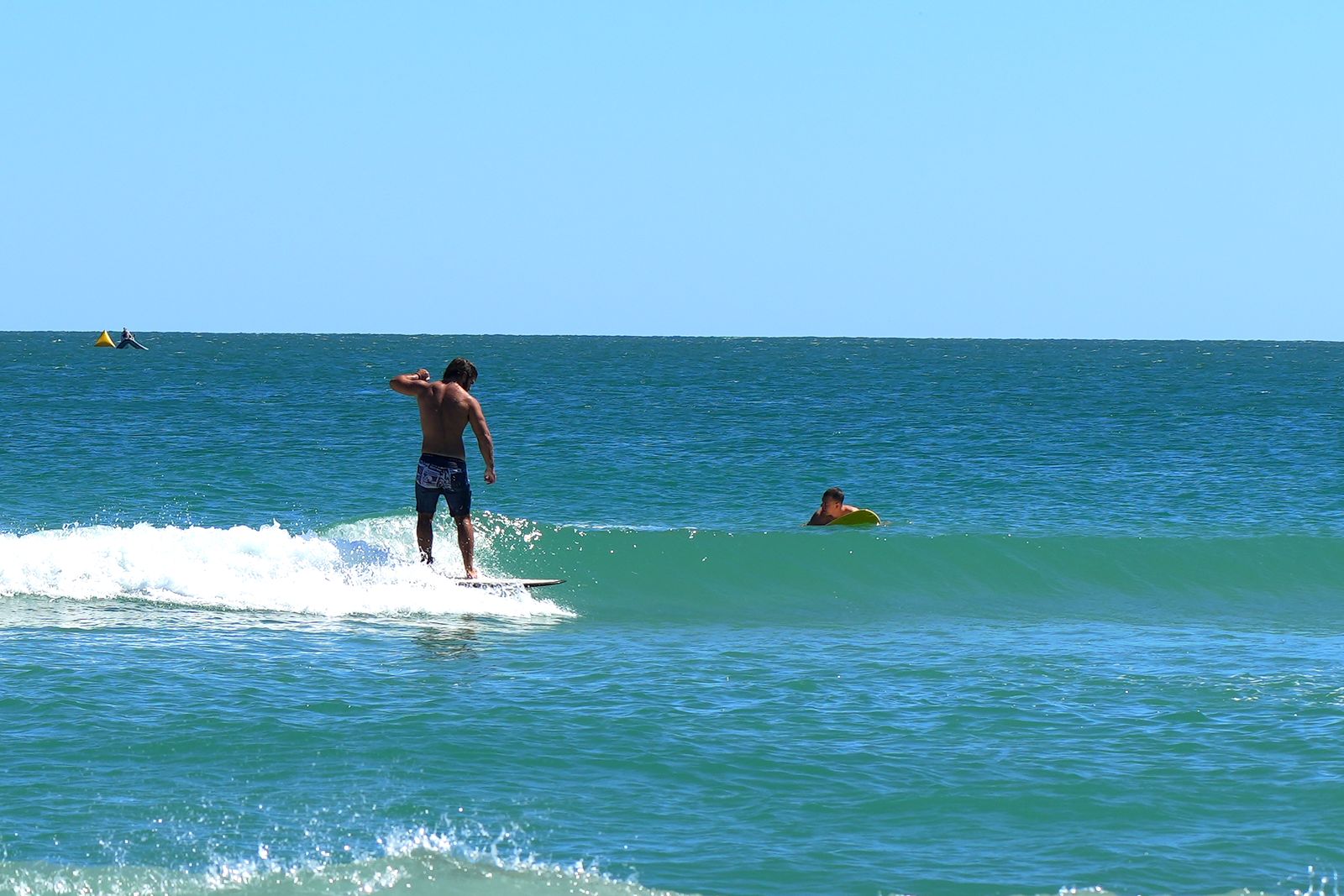 Turner riding out onto the shoulder with another surfer paddling behind